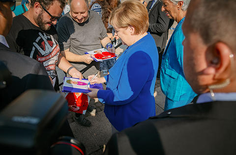 Bundeskanzlerin Angela Merkel unterschreibt Autogrammkarten. Die Sicherheitsvorkehrungen erfolgten in Abstimmung mit dem Bundeskanzleramt, dem Bundeskriminalamt und der Polizei Leipzig.