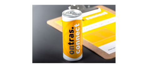 Ein Energy-Drink mit Aufdruck des Visuals der ONTRAS connect Kampagne im Vordergrund, im Hintergrund das Klemmbrett.