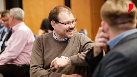 Einige Event-Teilnehmer sitzen in einem Seminarraum zusammen und nutzen die Möglichkeit, sich während der Kaffeepause über Erfahrungen auszutauschen.