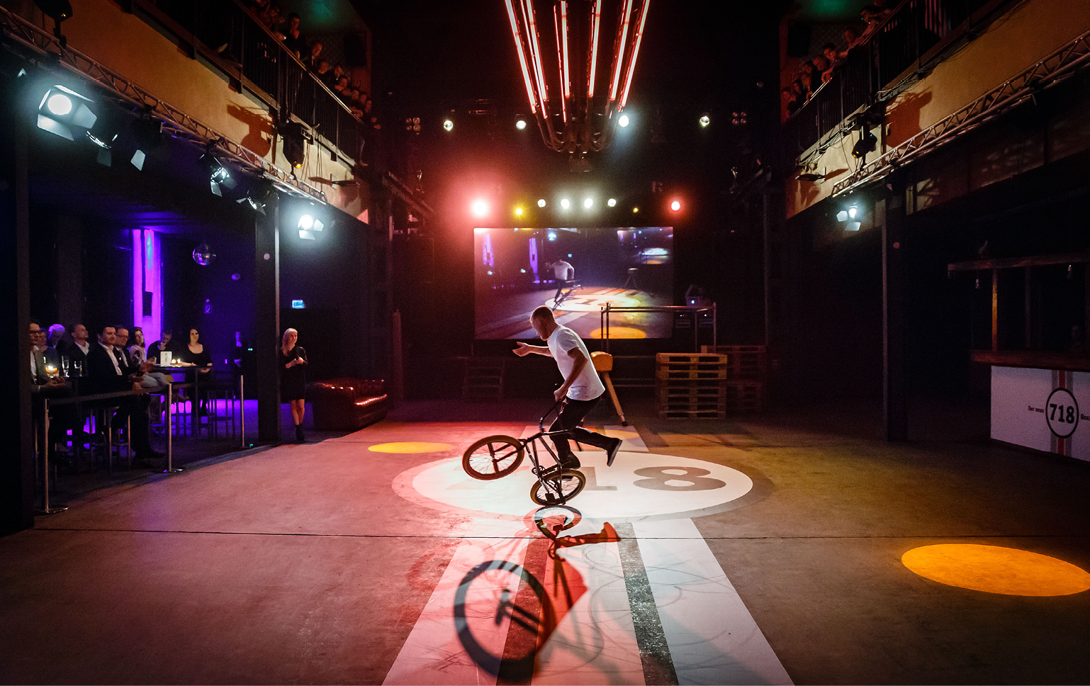 Ein Fahrradartist zeigt seine Performance mit seinem BMX Rad. Auf dem Boden ist das Boxster 718 Logo aufgeklebt.