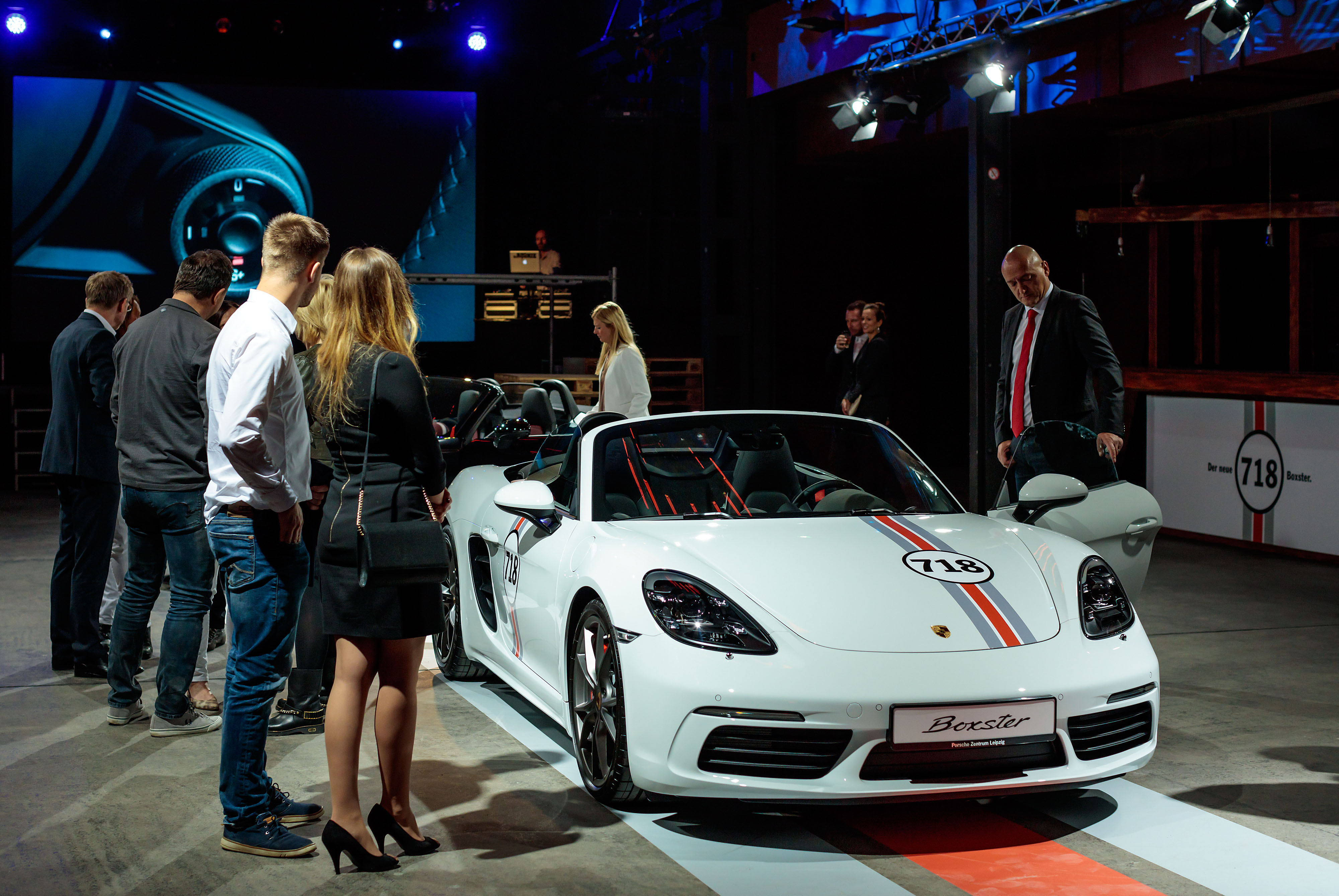Der Porsche Boxster 718 wird im Showroom von Eventgästen in Augenschein genommen.