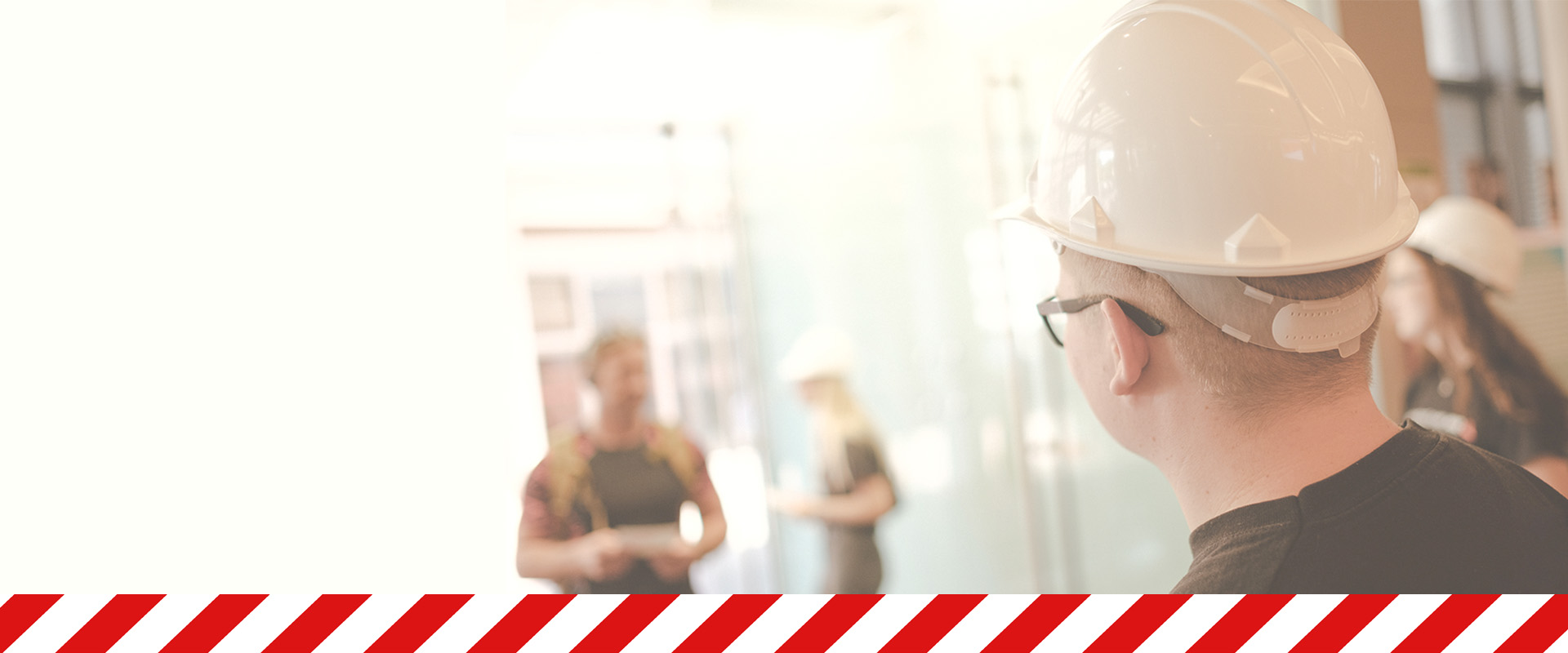 Auszubildende empfangen die Gäste der SWH Belegschaftsversammlung in Bauarbeiterkleidung und Helm, um eine Beteiligung an der Veränderung der Unternehmensstruktur zu versinnbildlichen.