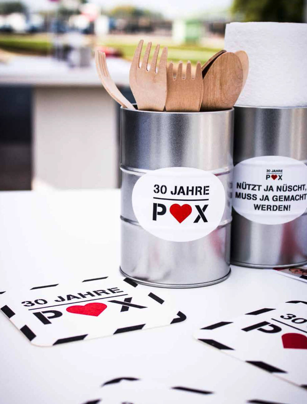 Besteckhalter im Event-Design zeigen Aufschriften wie  „30 Jahre POX“ oder „Nützt ja nüscht, muss ja gemacht werden.“