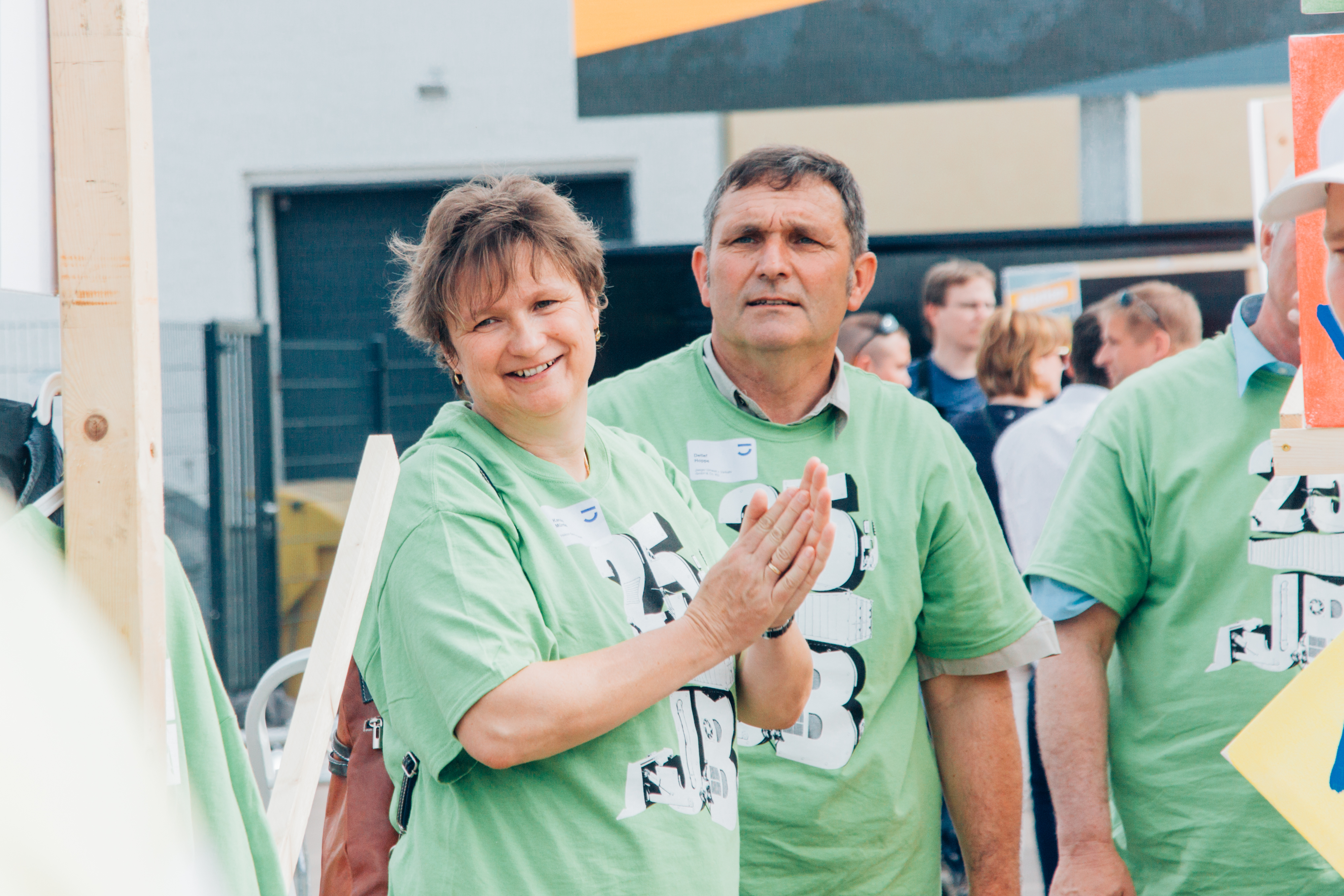 Eine Frau im grünen Team-T-Shirt feuert ihre Teamkollegen an.