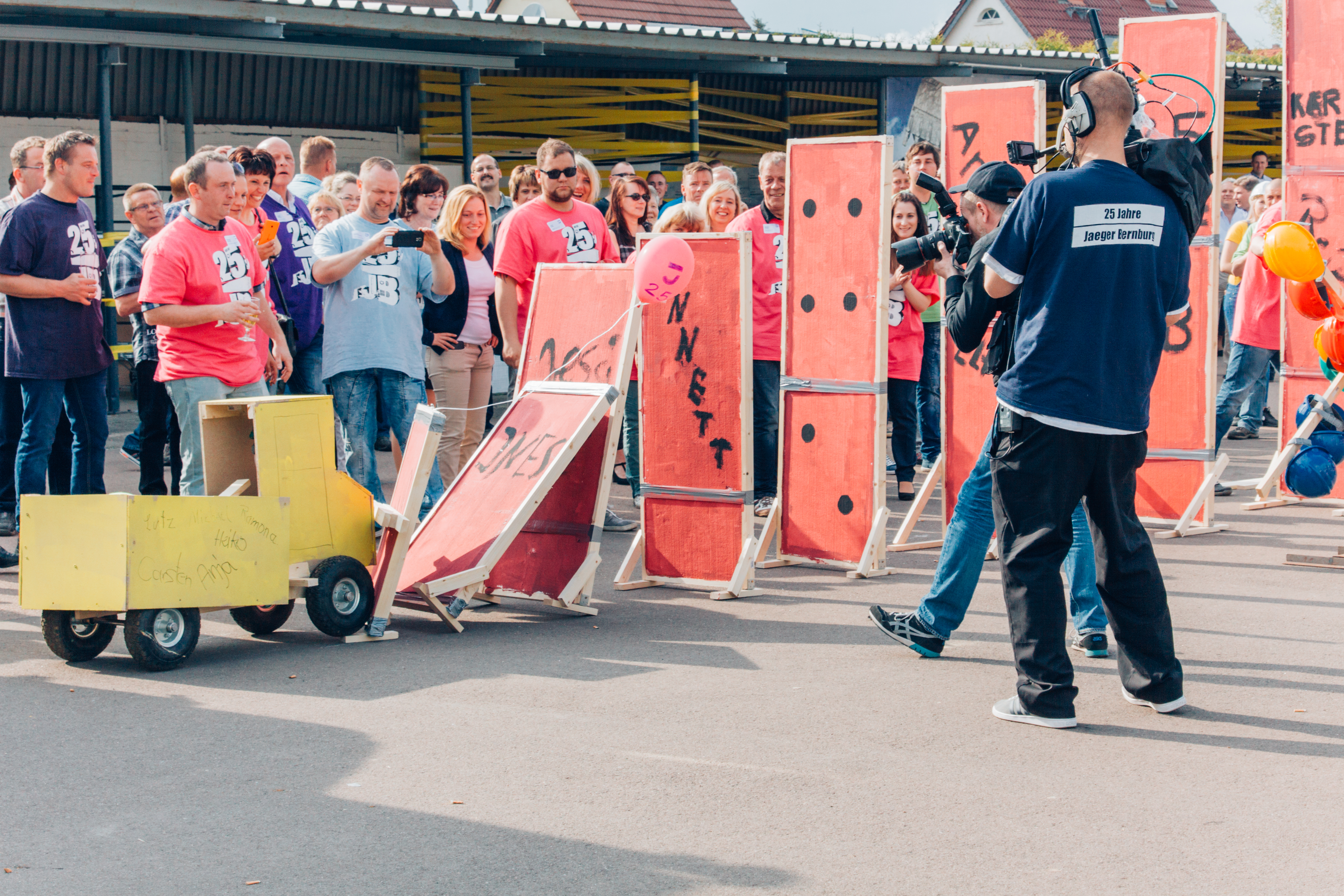 Dekorierte Stellwände fallen zu Beginn der Event-Kettenreaktion um wie Domino-Steine.