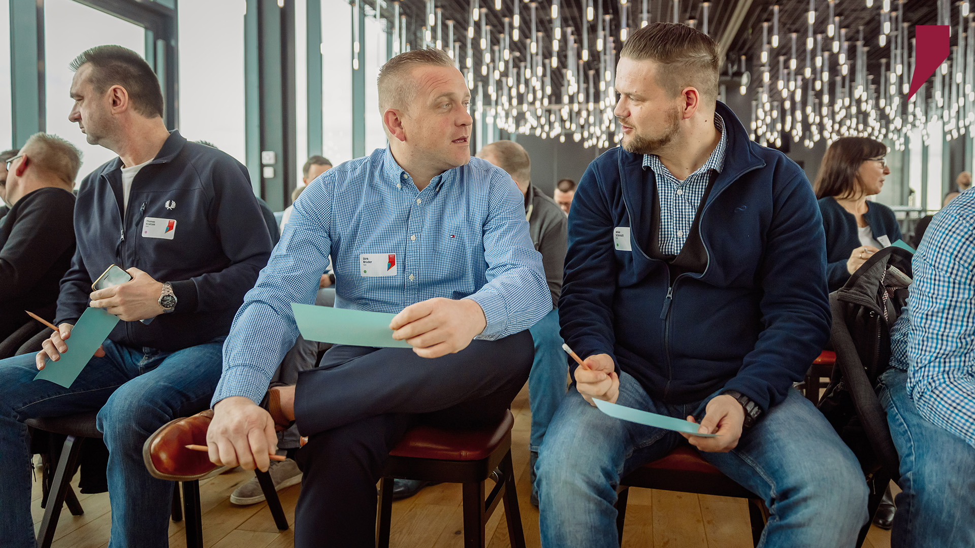 Zwei SWH-Führungskräfte diskutieren mögliche Fragen an die Geschäftsführung und halten Papier und Stift bereit, um diese zu notieren.