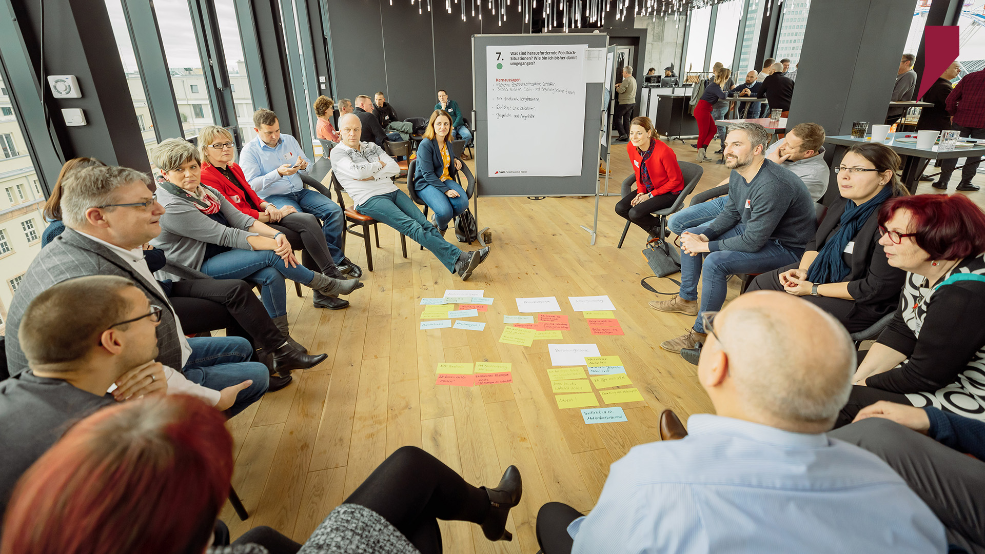 In einer Diskussionsrunde sitzt eine Gruppe von Führungskräften zusammen und bespricht, welche Kernaussagen dem Plenum vorgestellt werden sollen.